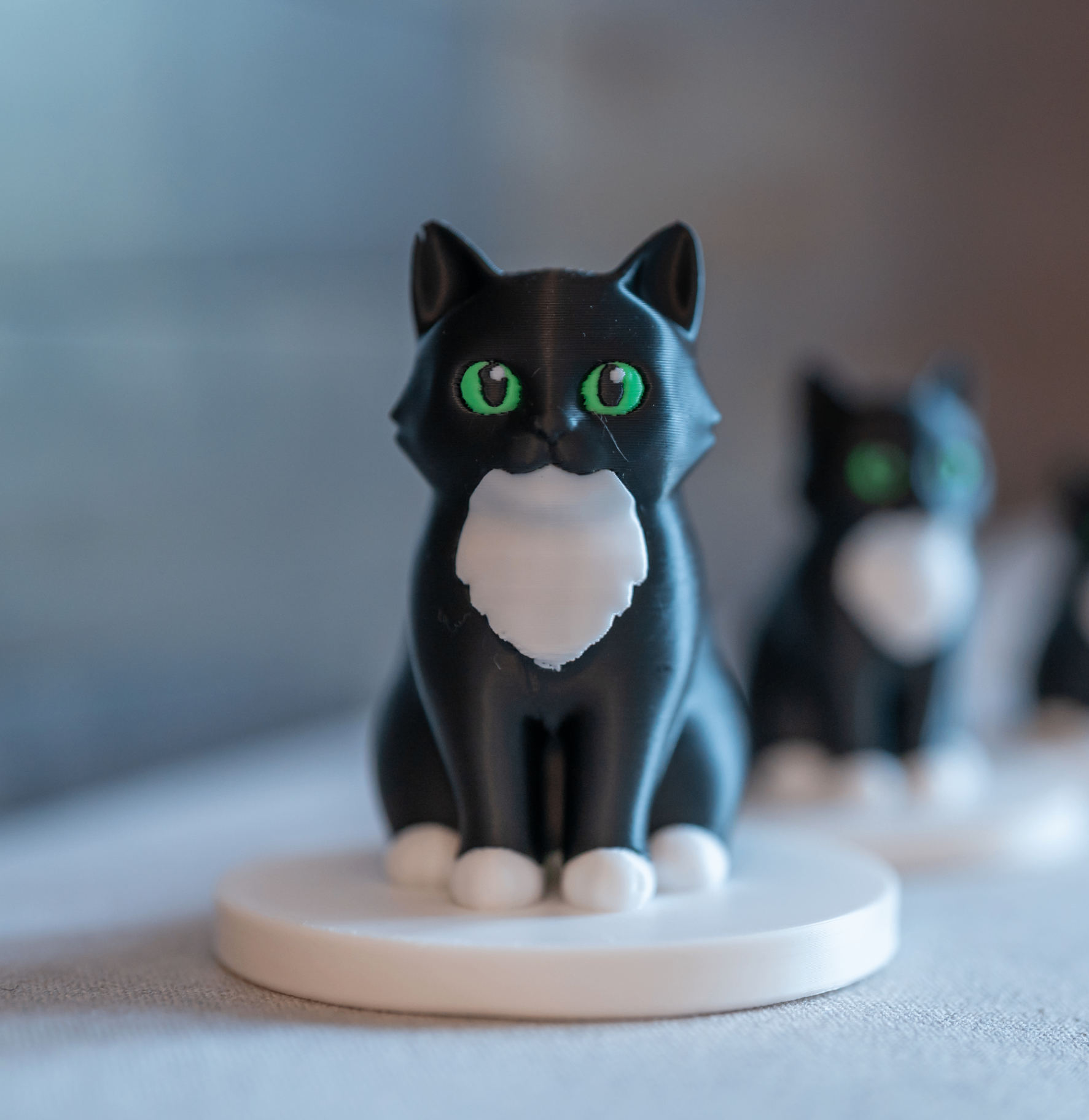 The finished 3D-printed pet memorial MiniMe figurine of a black-and-white cat with green eyes
