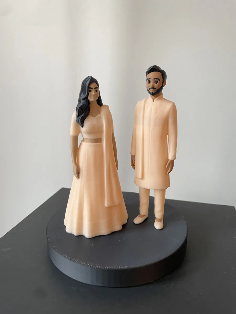 The finished 3D-printed MiniMe wedding gift figurine of the couple on a round base